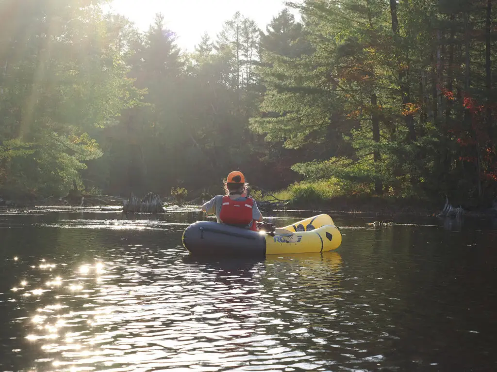 Laura Rose takes a photo from her packraft in fall